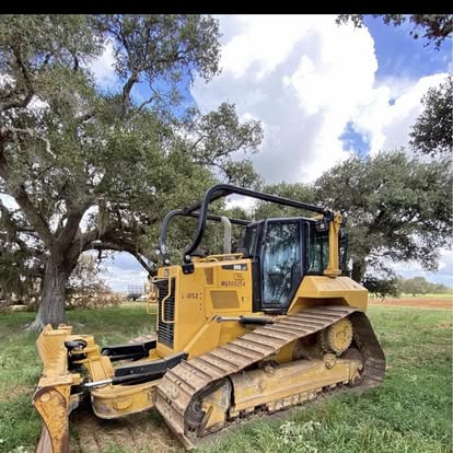 Yellow bulldozer in grassy field ready for excavation and land clearing