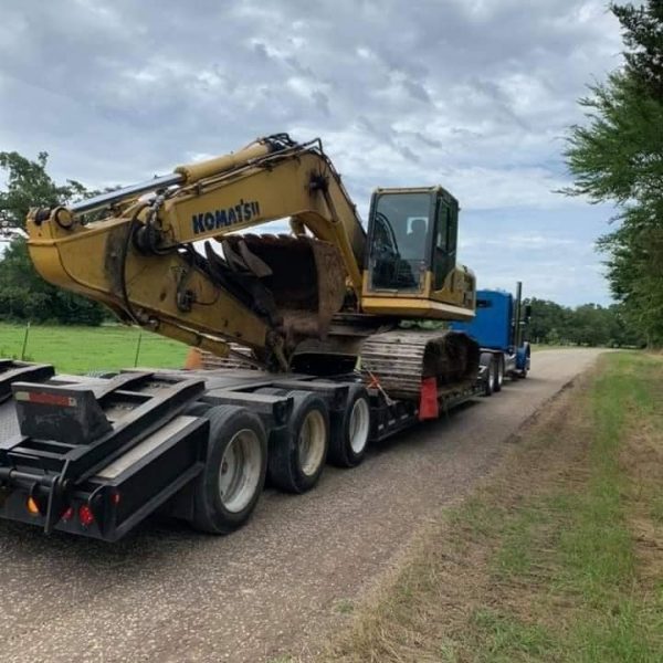 Excavator on trailer being transported to job site